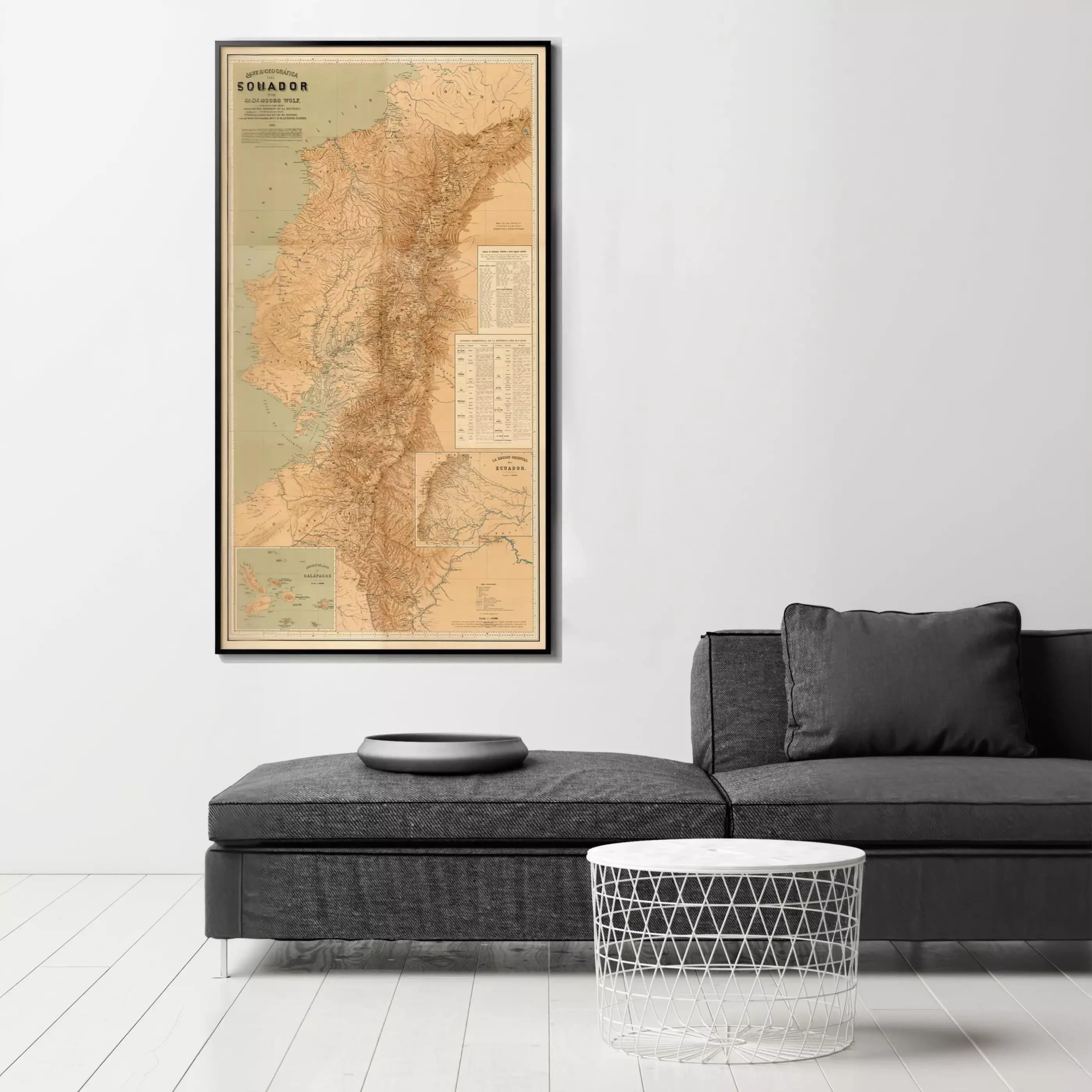 a large framed map of South America hanging on a wall, with a black couch and a round table in the foreground.