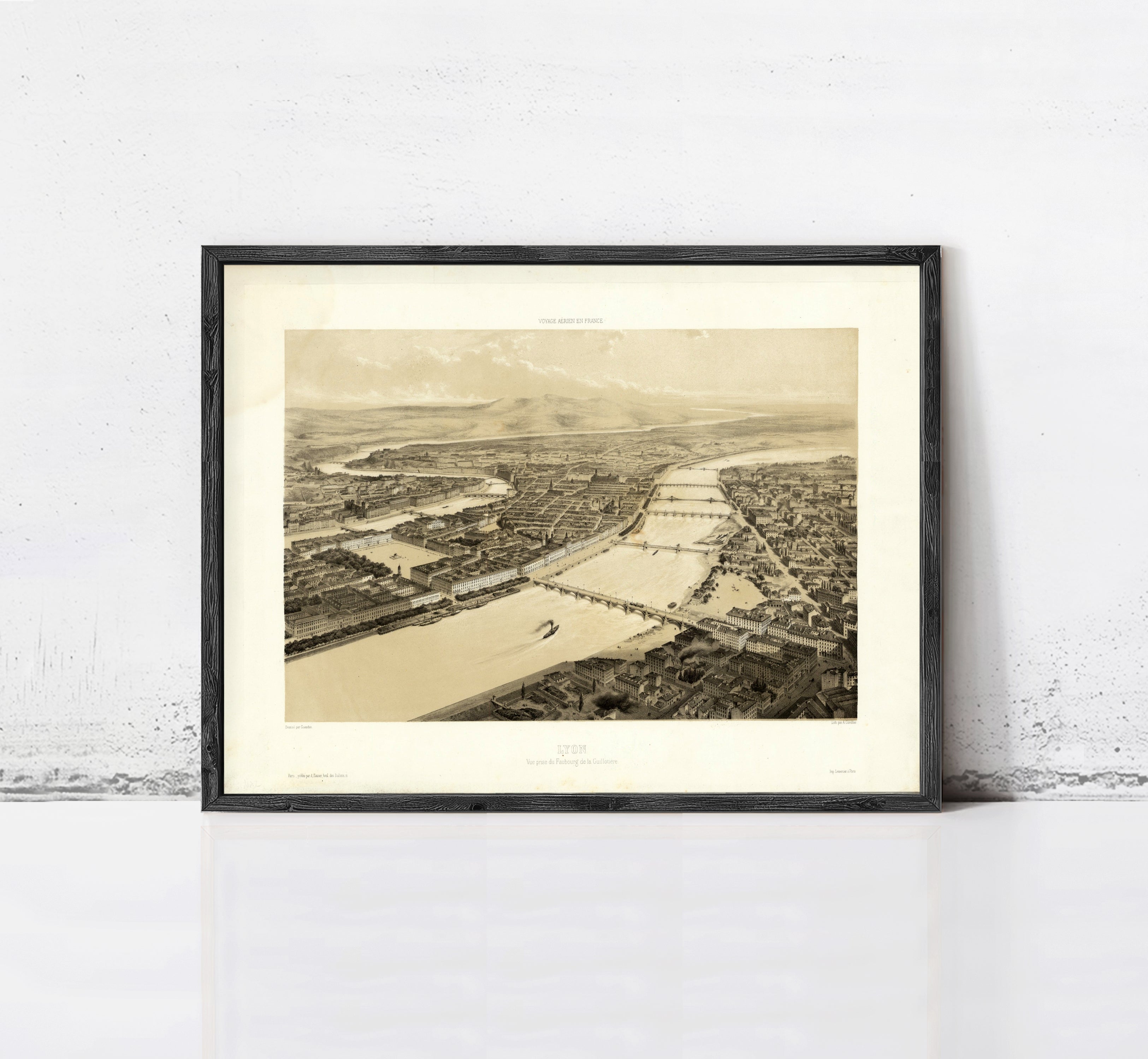 The image is a framed black and white aerial photograph of a cityscape, depicting a river or canal running through the center of the city.