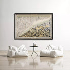 a large framed painting of a mountain landscape hanging on a white wall above a pair of white bean bag chairs and a small black table.