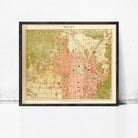 The image is a framed vintage map of a city, likely from the early 20th century, with a color palette of green, red, and yellow.