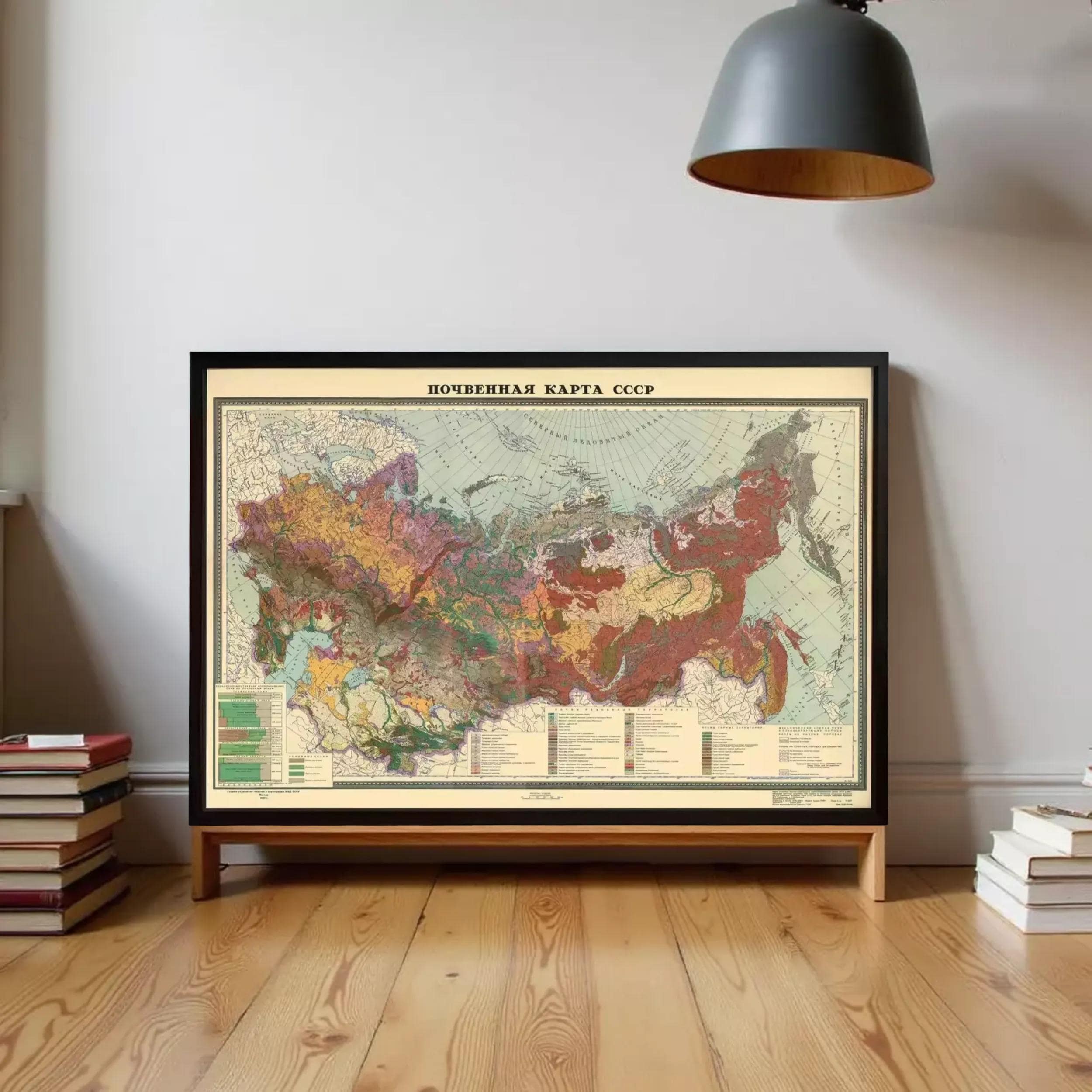 a large framed map of the Soviet Union, with a wooden floor and a stack of books on the side.