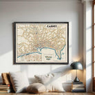 The image is a framed vintage map of the city of Cannes, France, depicting the city's streets, landmarks, and surrounding areas.