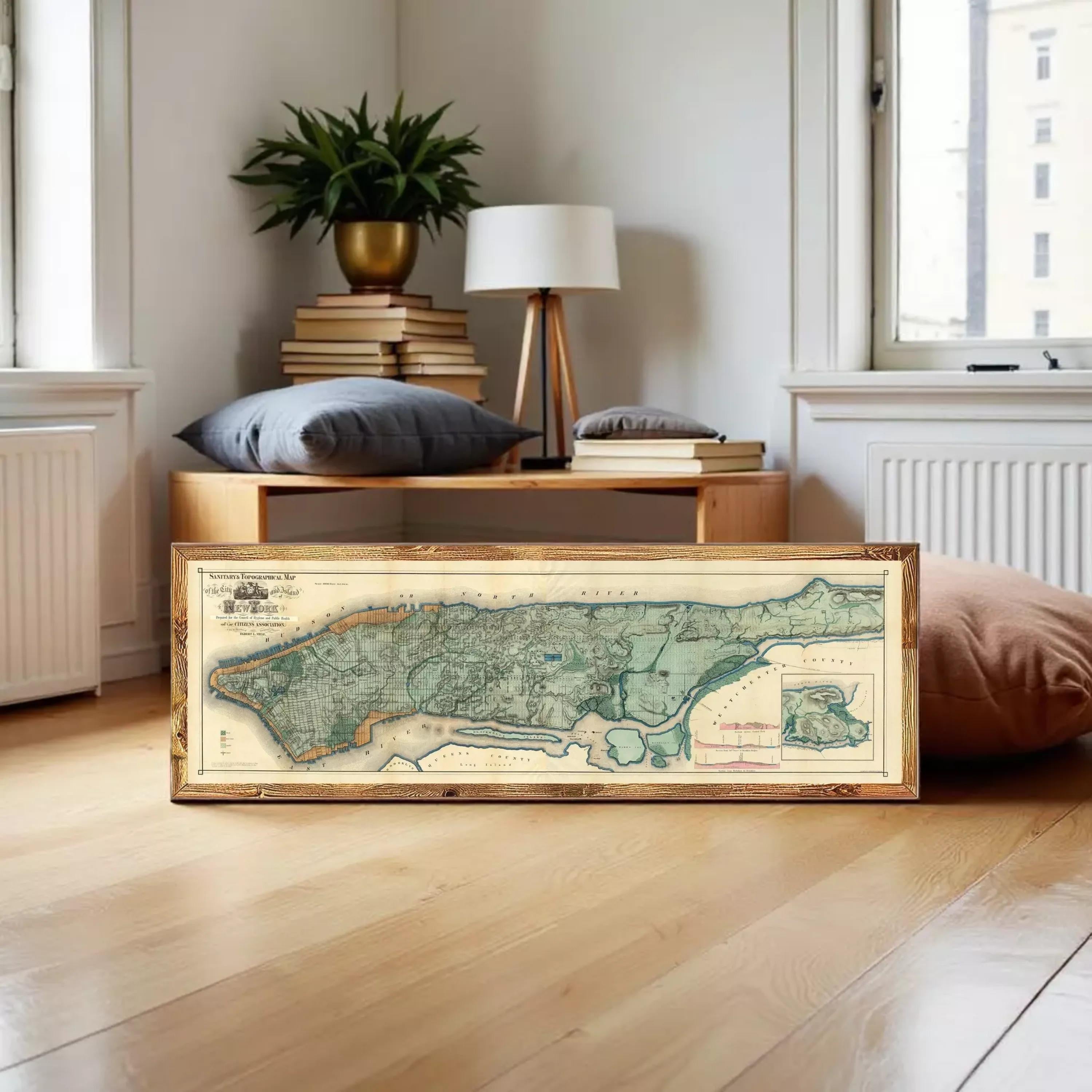 A framed map of New York City, showing the city's streets and surrounding areas, is displayed against a white wall.