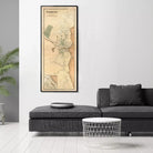 a large framed map of Plymouth, Massachusetts, hanging on a white wall above a black couch and a round table.