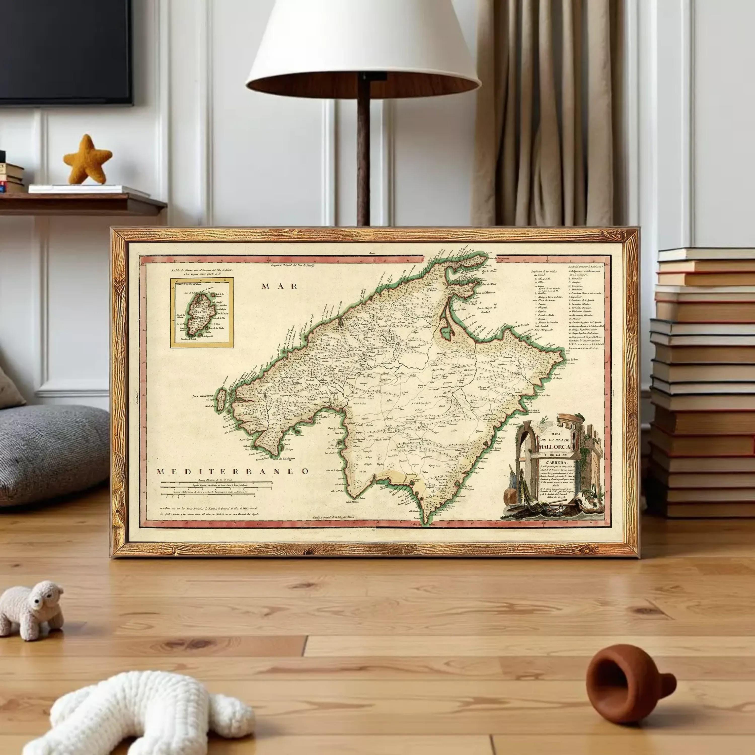 a framed map of the Mediterranean region, with a lamp and books in the background.