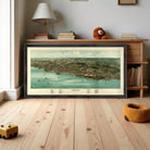 The image is a framed aerial map of a coastal city, depicting the city's layout, coastline, and surrounding areas.