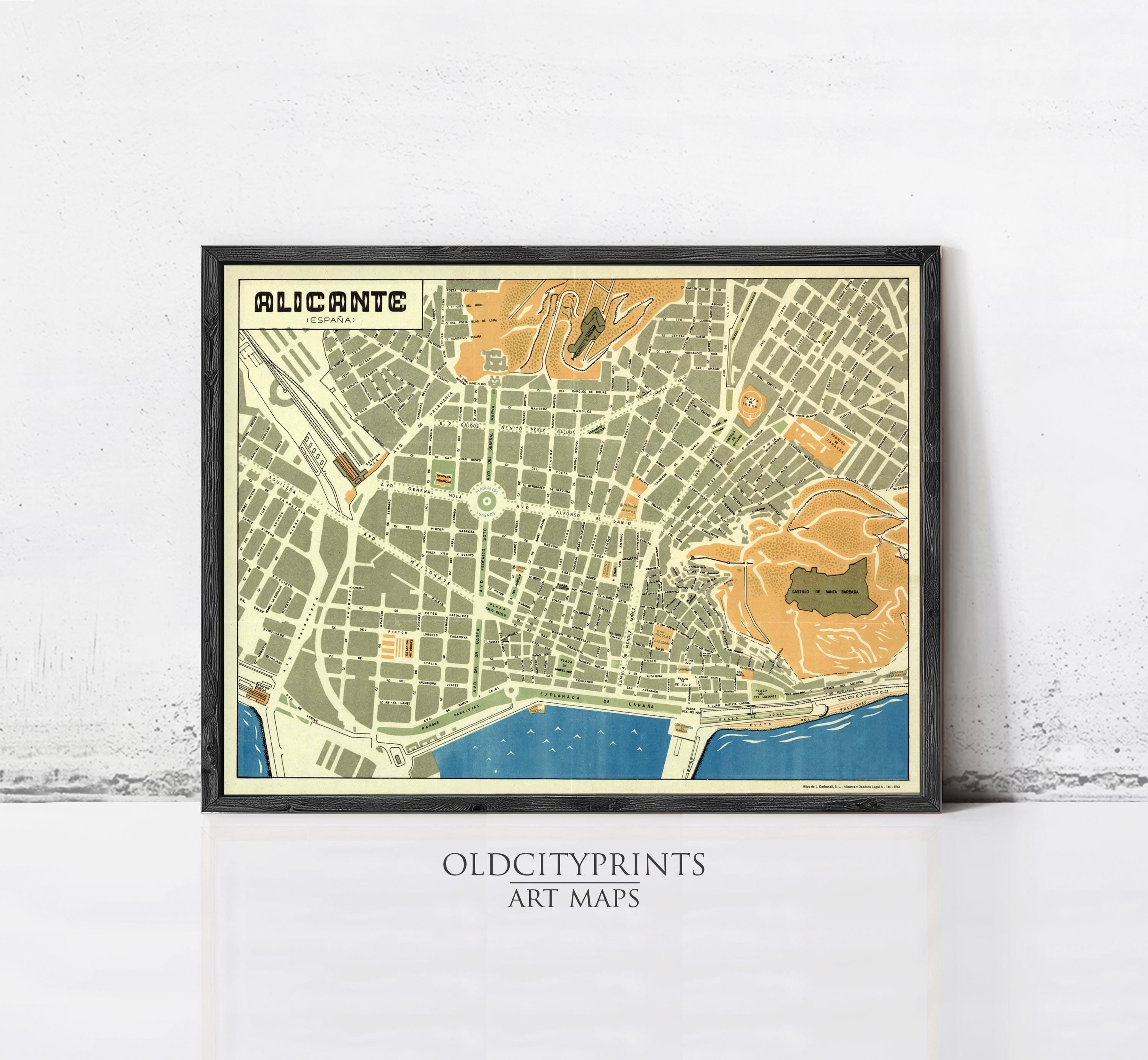 The image is a framed vintage map of the city of Alicante, Spain, depicting the city's streets, landmarks, and surrounding areas.