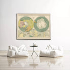 a large vintage map of the world hanging on a white wall, with two white bean bag chairs positioned in front of it.