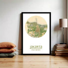 A framed poster of a map of Jakarta, Indonesia, displayed on a wall next to a stack of books and a lamp.