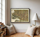 The image is a framed vintage map of a city, depicting a densely populated urban area with numerous buildings and streets.