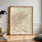 a large framed map of Turkey, with a wooden frame and a black lamp on a shelf next to it.