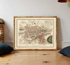 The image is a framed map of a city, likely London, with various landmarks and streets depicted.