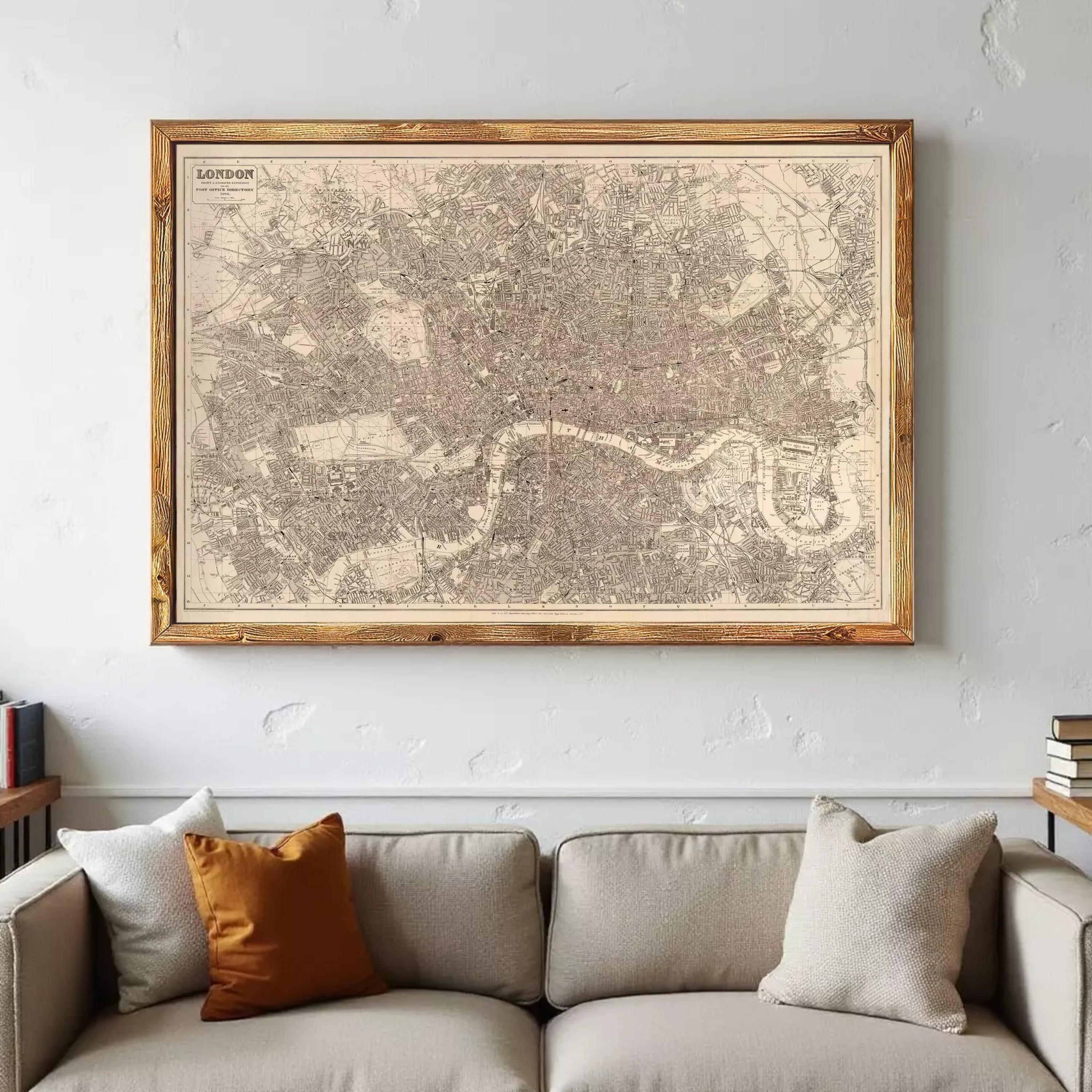 A large framed map of London hangs on the wall above a beige couch with two throw pillows.
