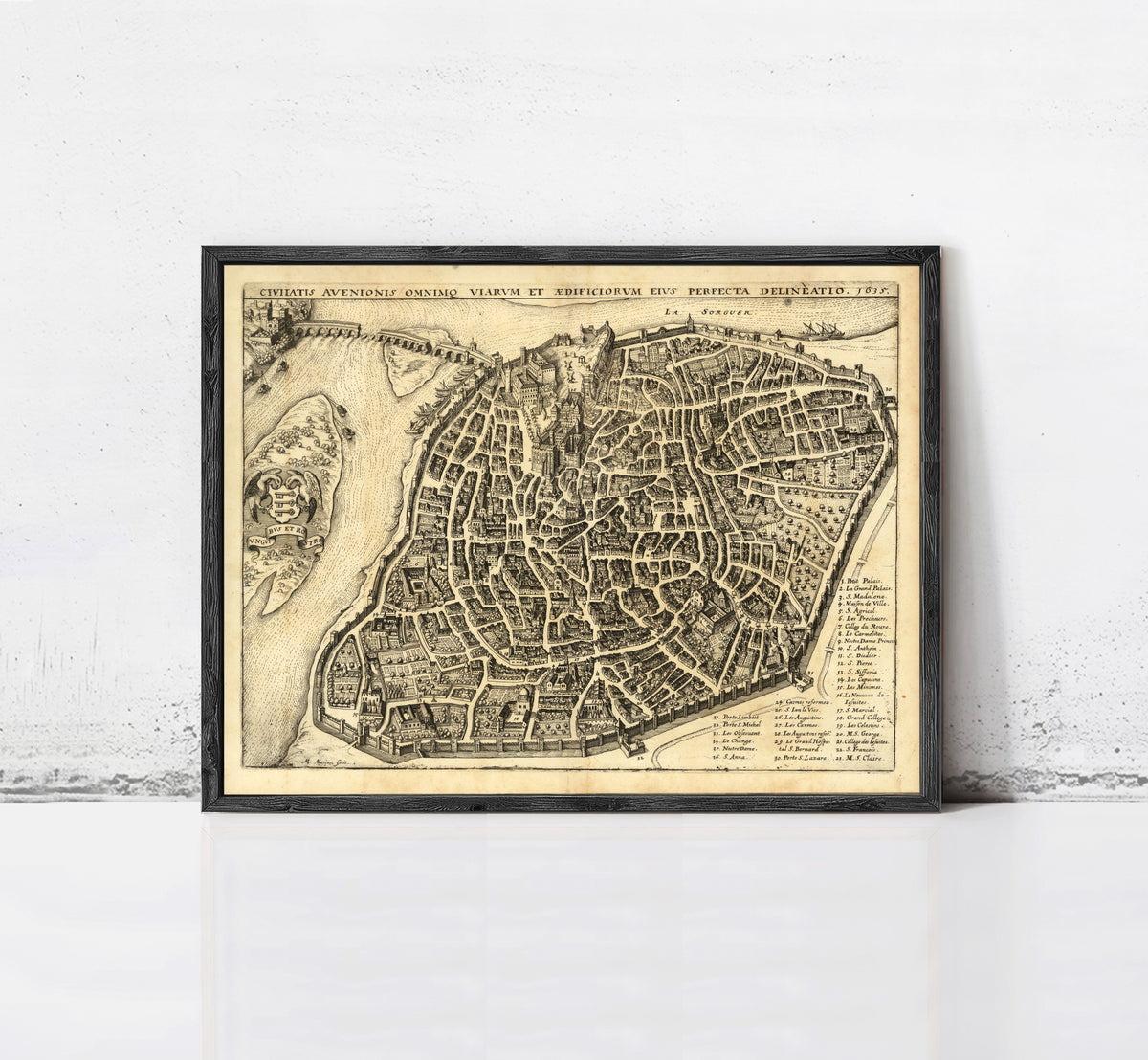 The image is a framed antique map of a city, likely from the 16th century, depicting a detailed layout of the city's streets and surrounding areas.