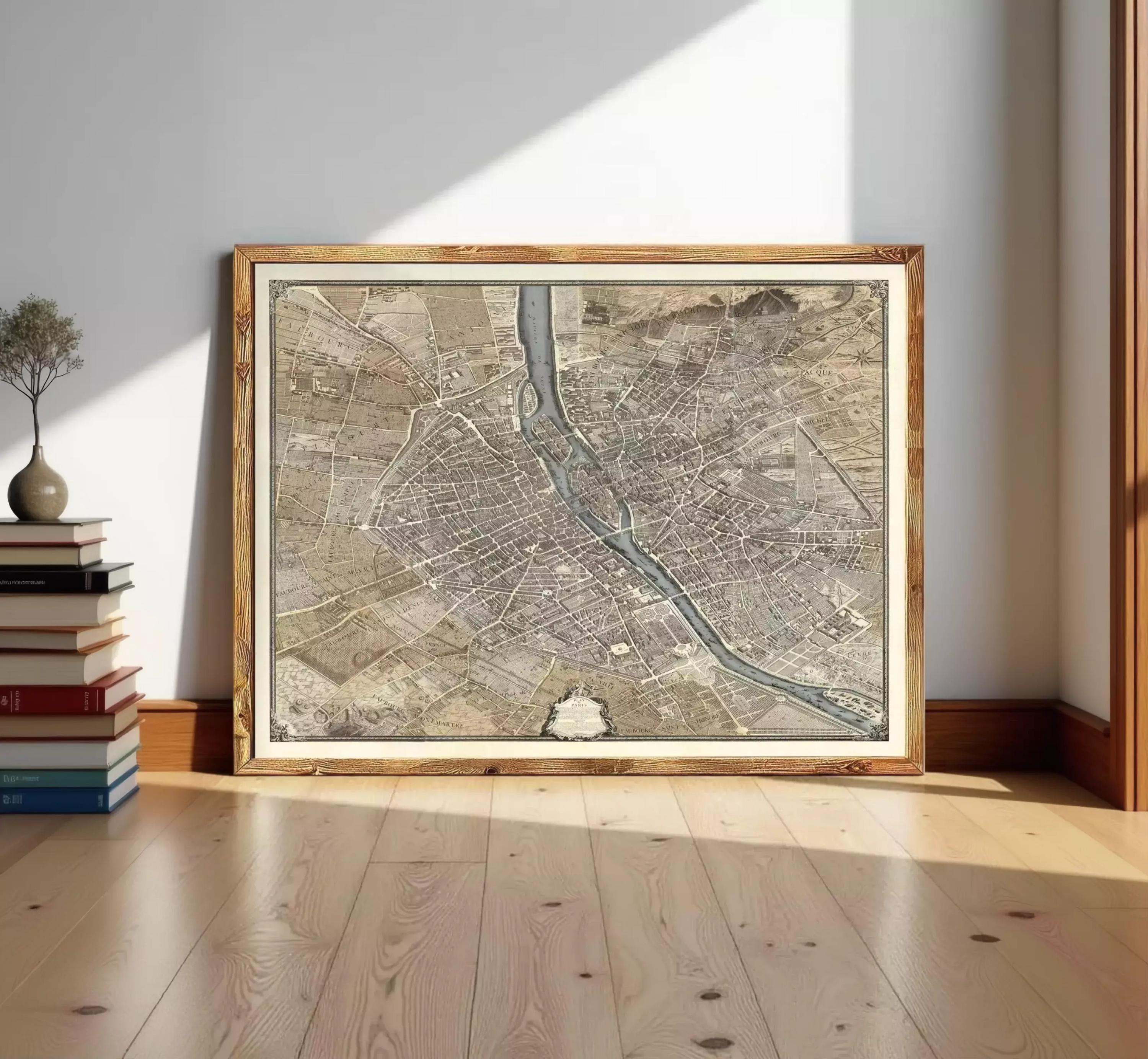 A large framed map of a city is displayed on a wooden floor in a room with a bookshelf in the background.