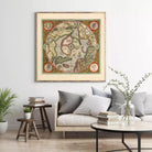a large framed map of the world hanging on a wall in a living room setting.