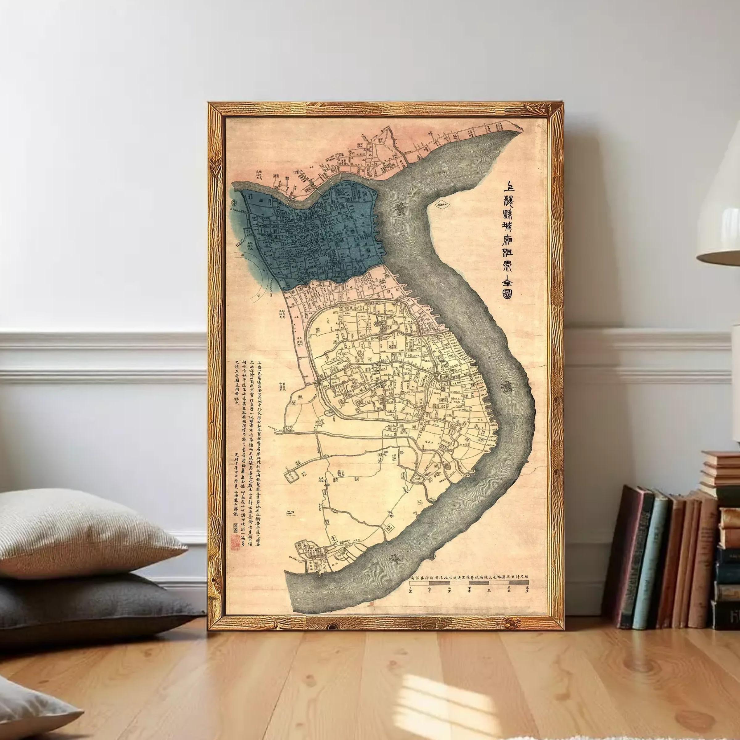 The image is a framed map of a city, likely from an ancient Chinese or Japanese period, with a river running through it. The map appears to be in Chinese or Japanese script, and the frame has a wooden border. The map is displayed against a white wall, which highlights its details and colors.