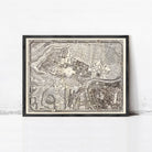 The image is a framed antique map of a city, likely from the 18th century, displayed on a white wall.