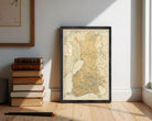 a framed map of Finland, with a stack of books and a pile of pencils on the floor in front of it.