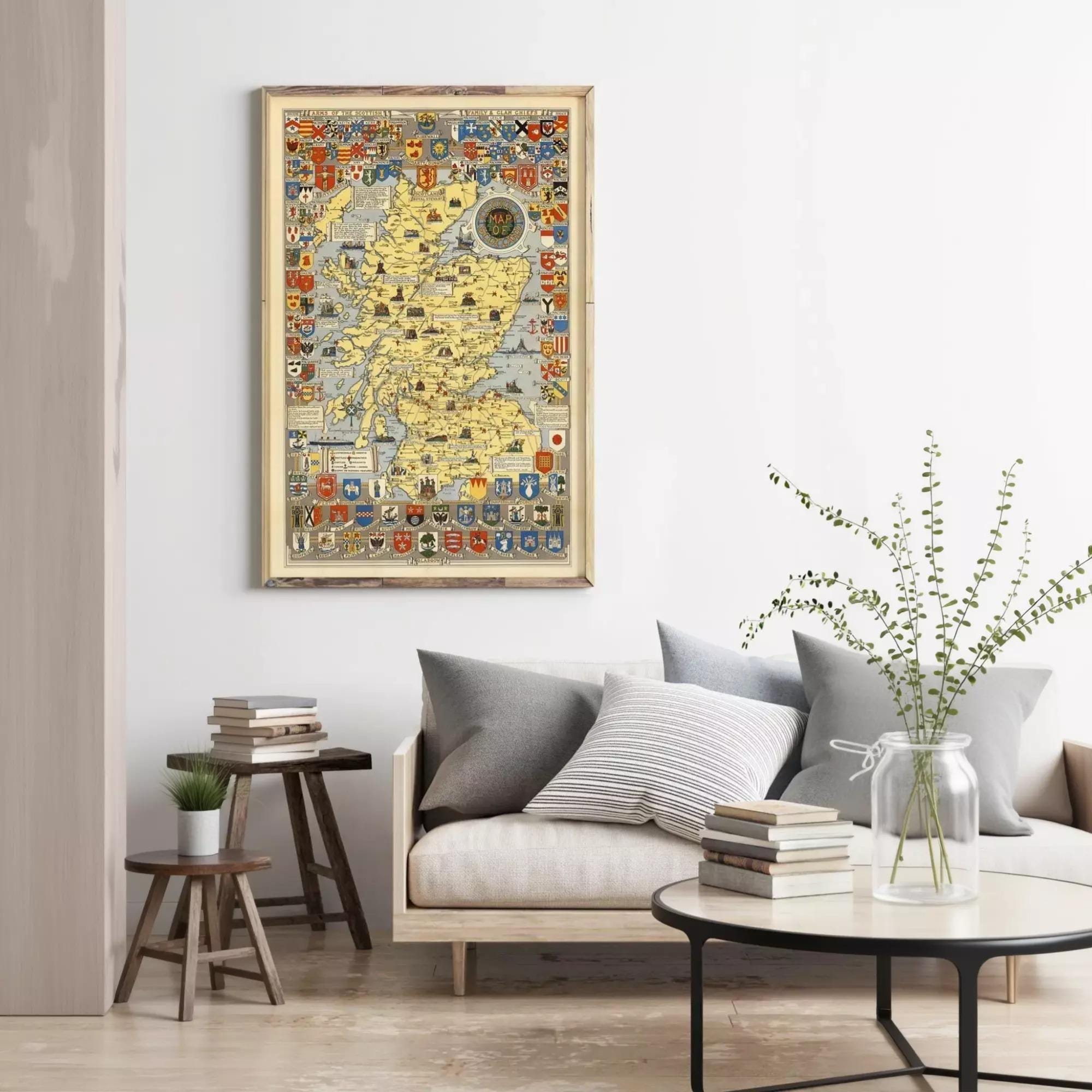 a living room with a large framed map hanging on the wall, a couch with pillows, a coffee table with books, and a vase with greenery.