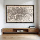 A large framed map of London is displayed on the wall above a wooden entertainment center with drawers.