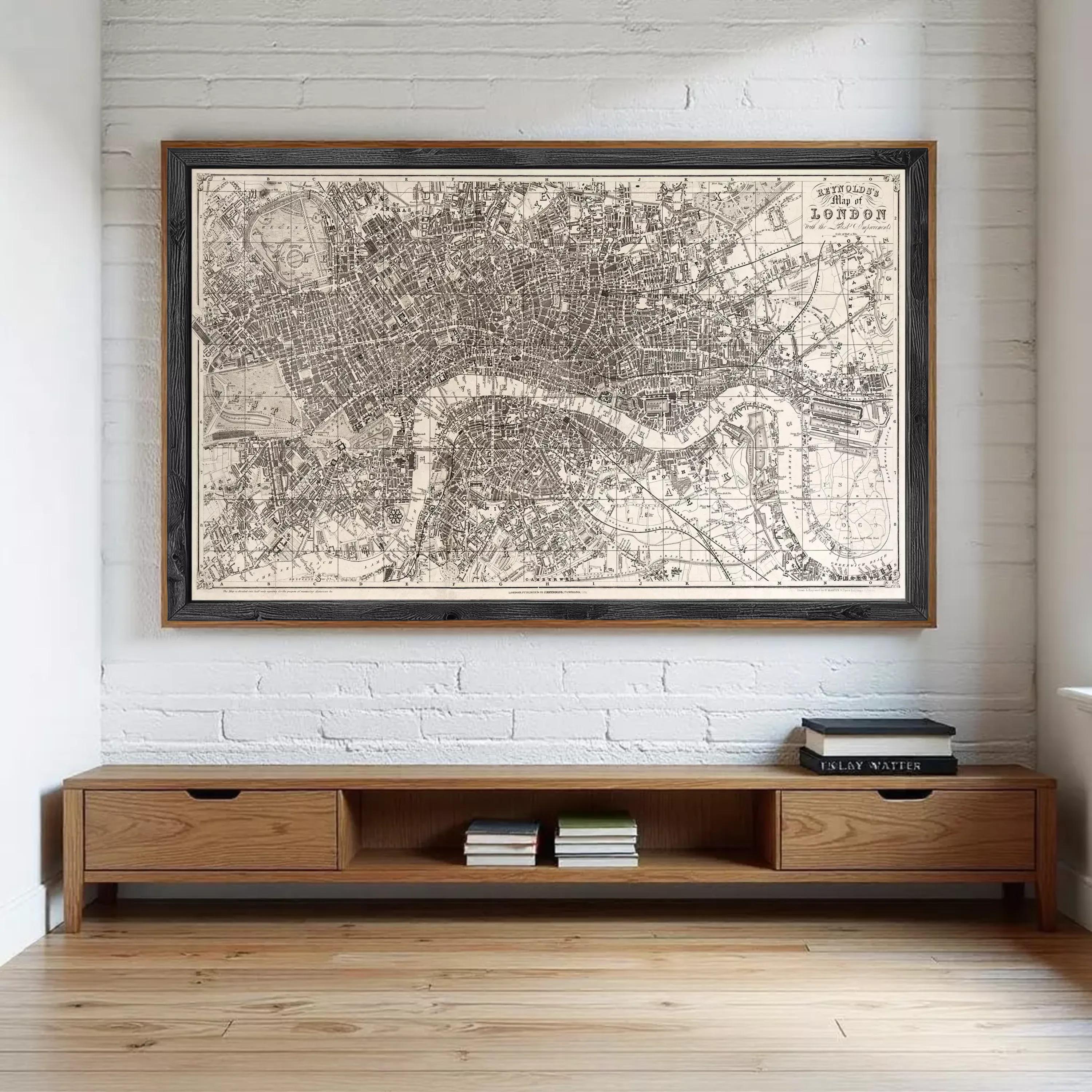 A large framed map of London is displayed on the wall above a wooden entertainment center with drawers.