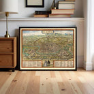 a framed map of Rome, with a wooden floor and a lamp visible in the background.