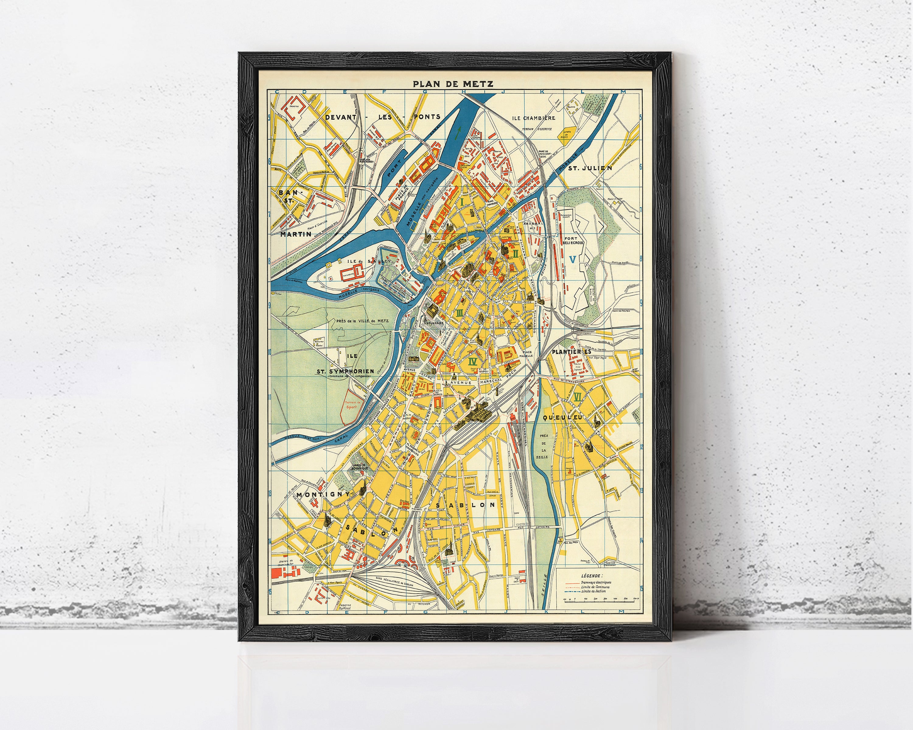 The image is a framed vintage map of a city, depicting various landmarks and streets in a detailed and colorful manner.
