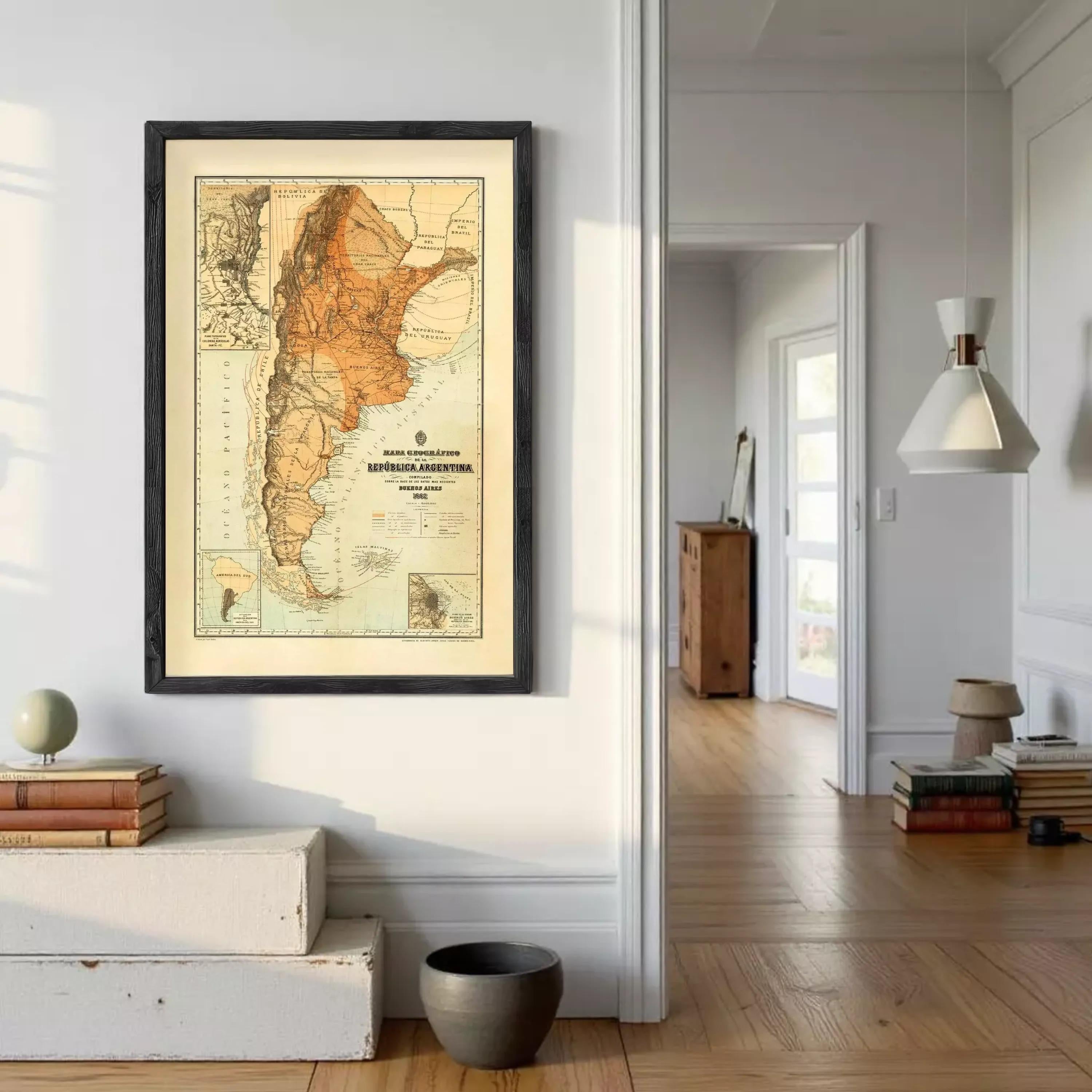 a framed map of South America hanging on a wall, with a wooden floor and a bookshelf visible in the background.