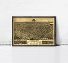 The image is a framed vintage map of a city, depicting a detailed aerial view of the urban landscape.