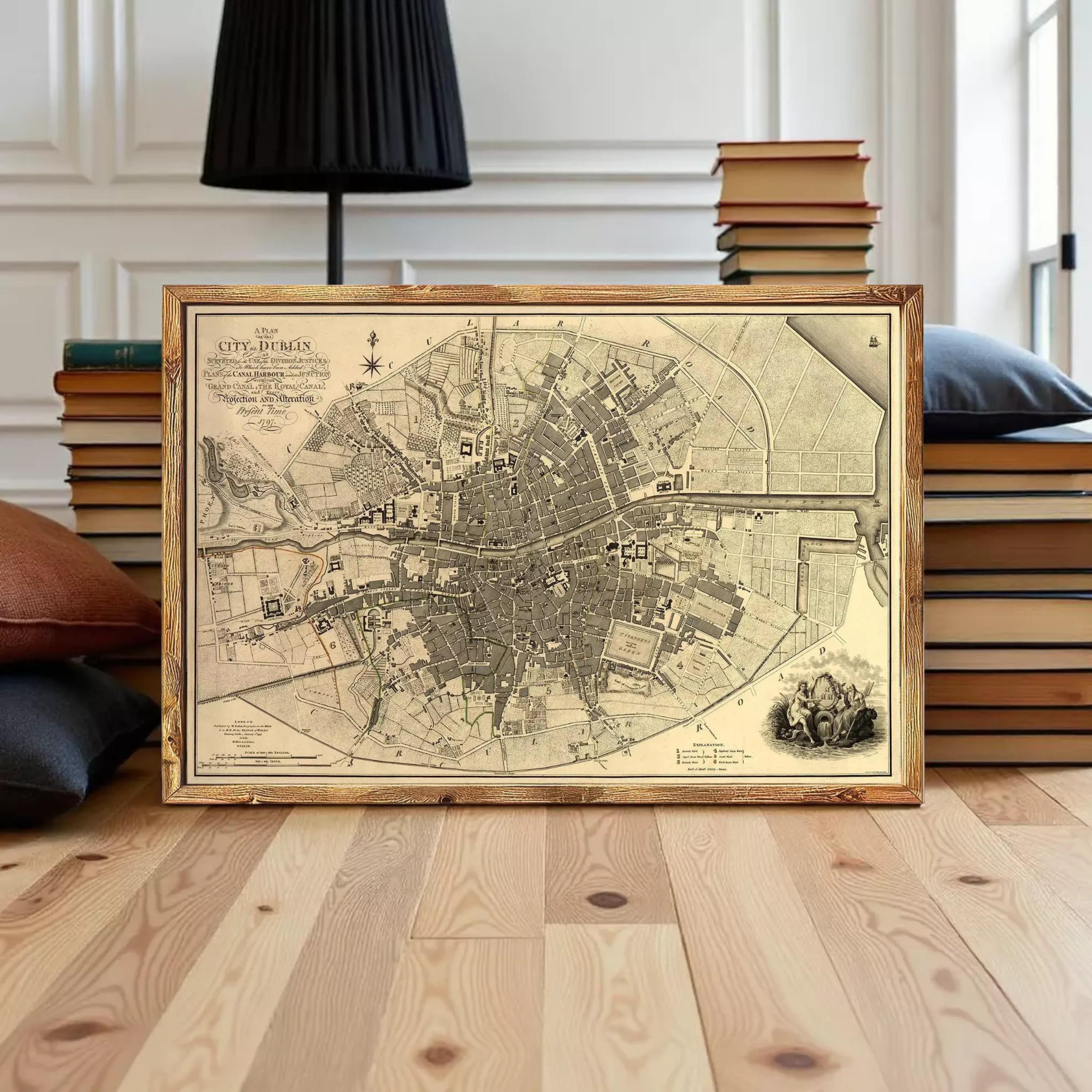 A framed map of a city, likely Paris, displayed on a wooden floor in front of a stack of books.