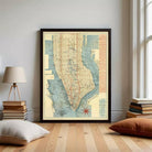 The image is a framed vintage map of New York City, depicting the city's streets and neighborhoods in a detailed and colorful manner.