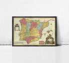 The image is a framed vintage map of Spain, featuring colorful regions and a coat of arms.