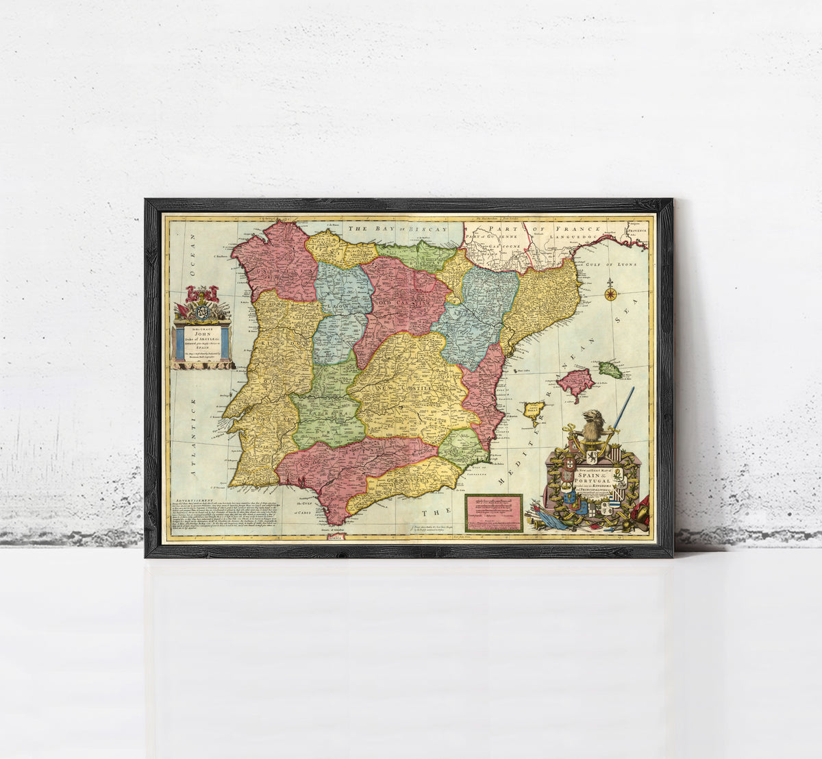 The image is a framed vintage map of Spain, featuring colorful regions and a coat of arms.