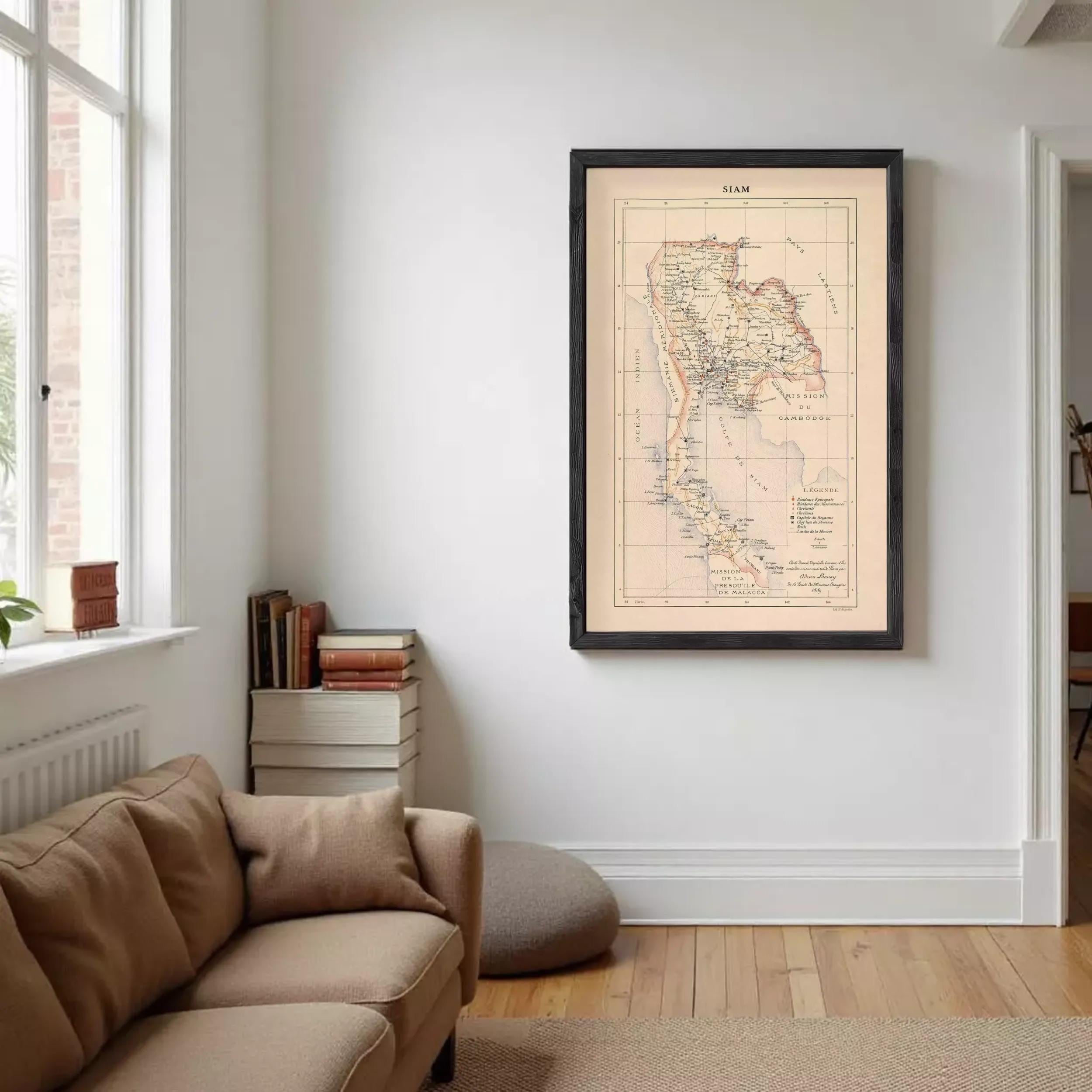 a living room with a brown sofa, a bookshelf, and a framed map of Thailand hanging on the wall.