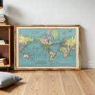 The image is a framed vintage map of the world, depicting the continents and oceans in a colorful and detailed manner.