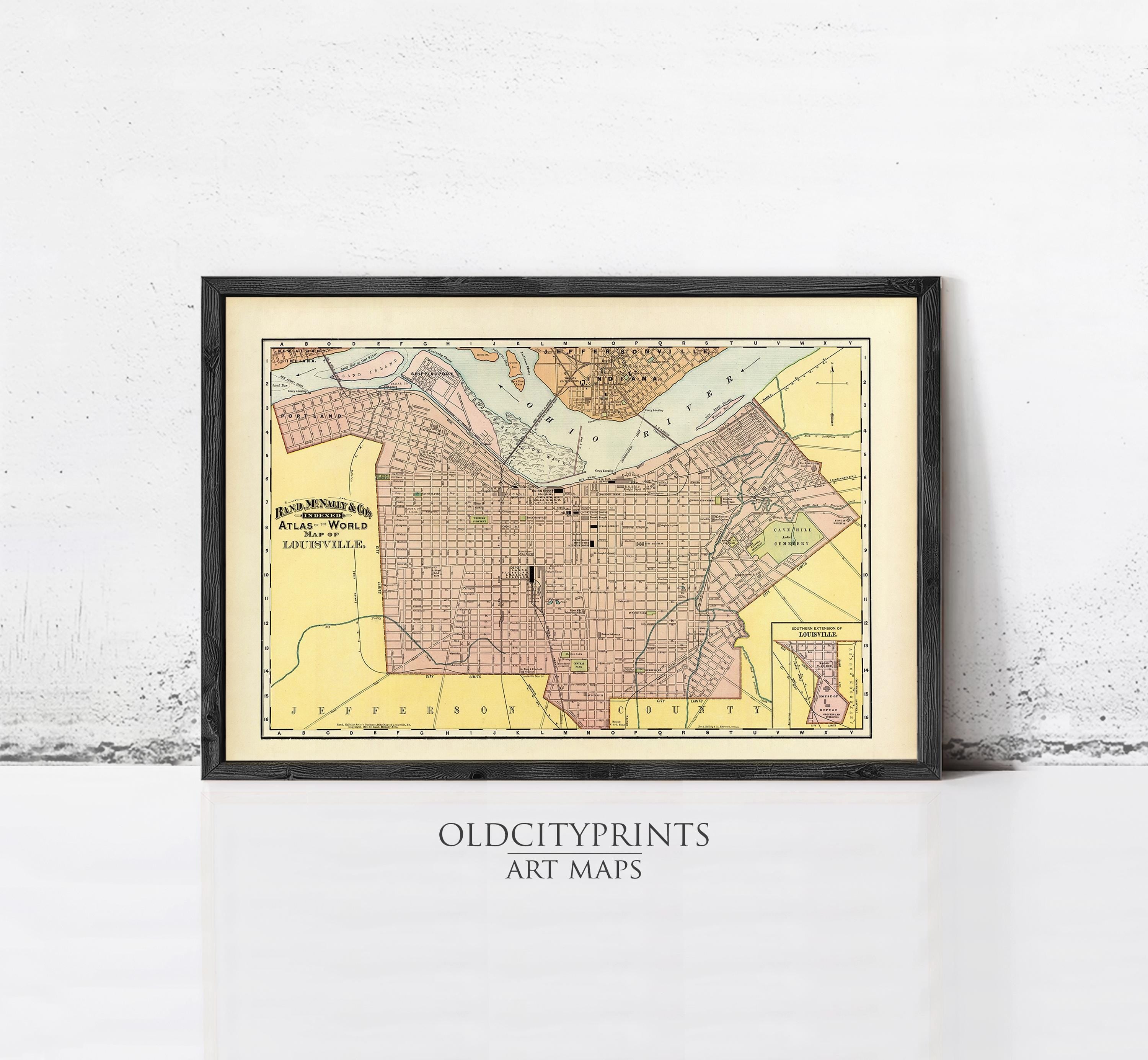 The image is a framed vintage map of a city, likely from the early 20th century, displayed on a wall.