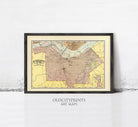 The image is a framed vintage map of a city, likely from the early 20th century, displayed on a wall.