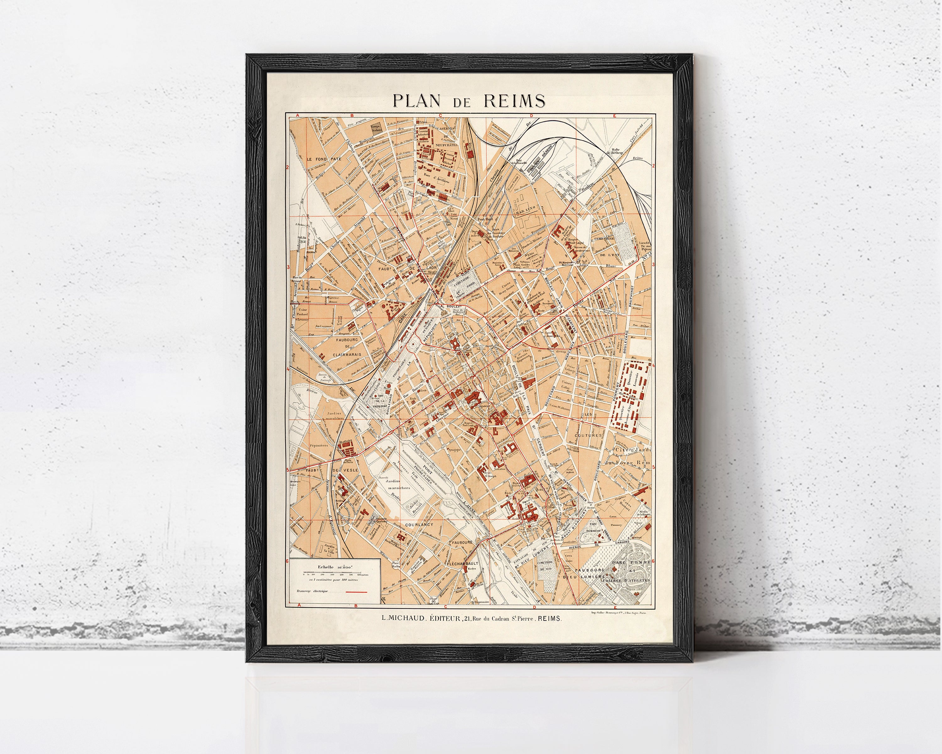 The image is a framed map of Reims, France, depicting the city's streets and landmarks.