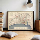 The image is a framed map of a city, likely a coastal city, with various streets, landmarks, and bodies of water depicted.