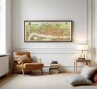a living room with a large framed map of London hanging on the wall above a brown armchair. There are also a few books and a lamp on a side table in the room.