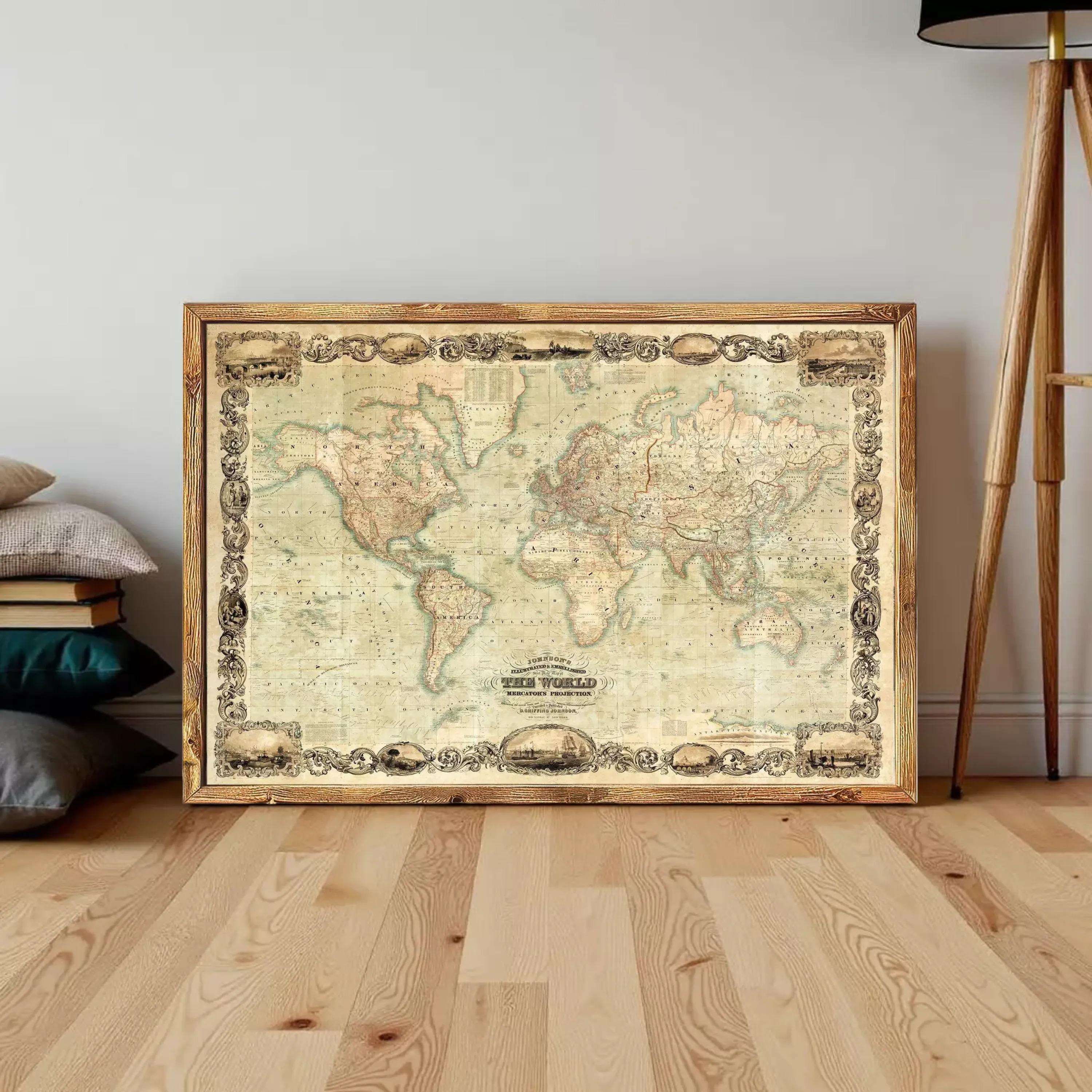A large, antique world map in a wooden frame is displayed on a wooden floor against a white wall.