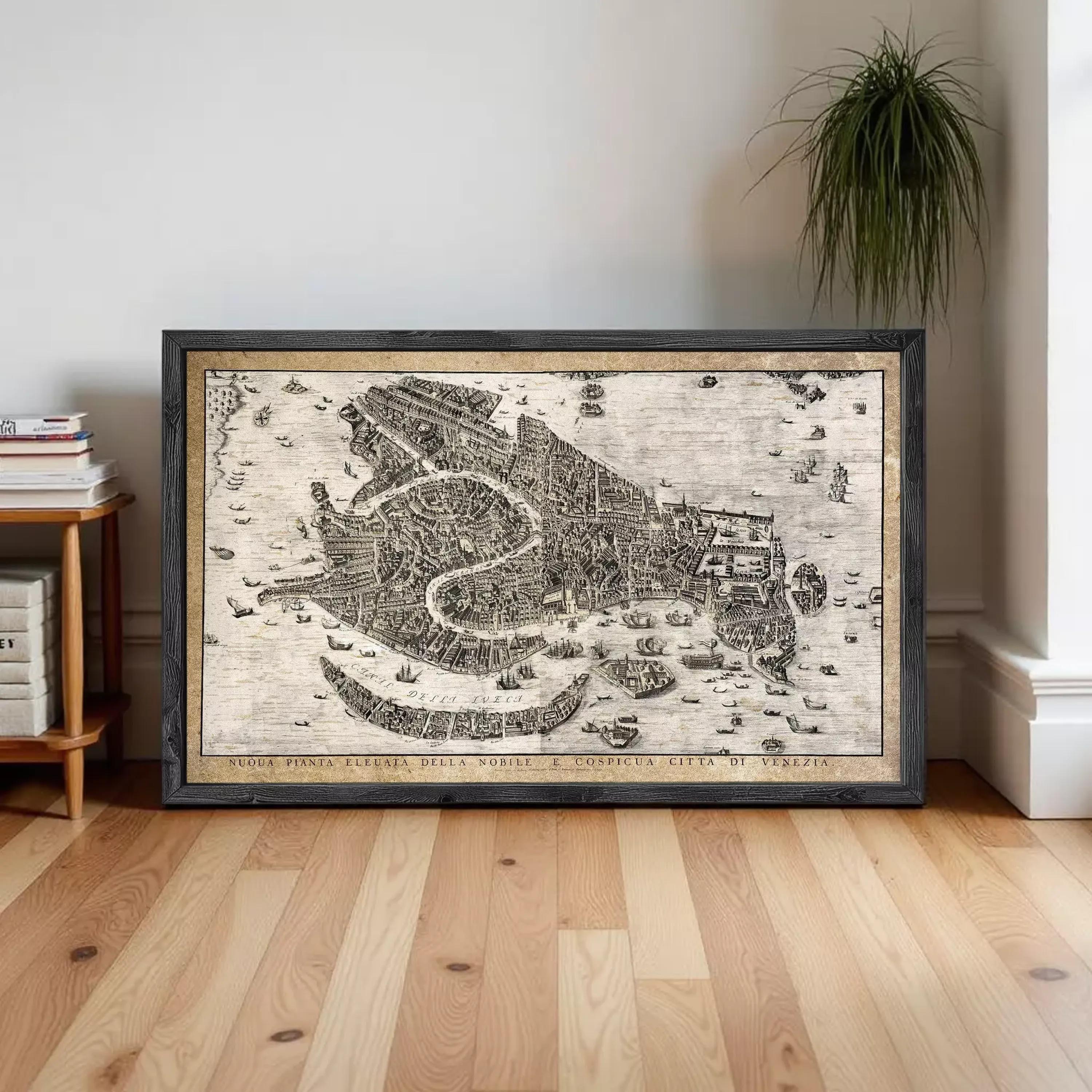 A framed map of Venice, Italy, depicting the city's layout and surrounding areas, is displayed on a wooden floor in a room.