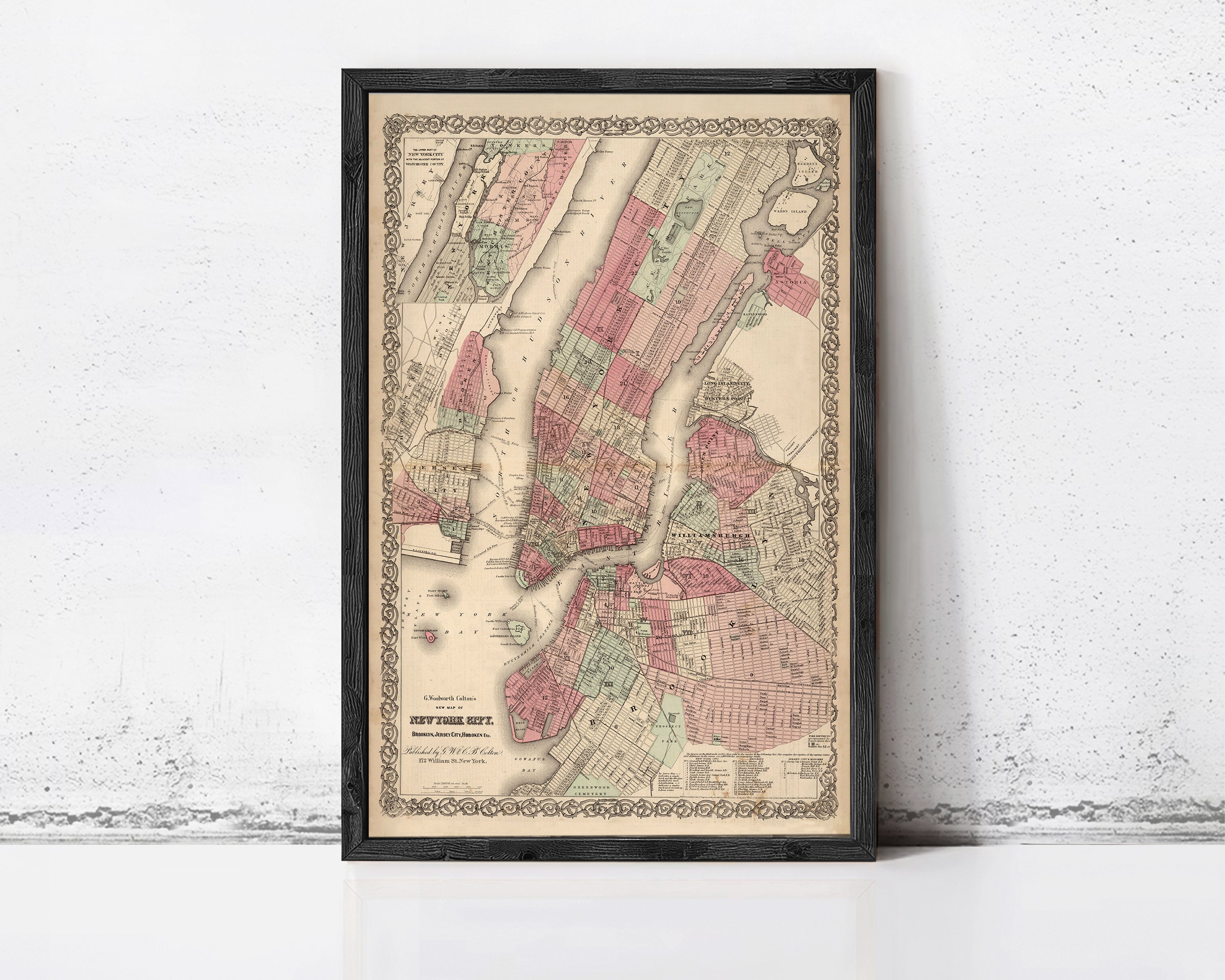 The image is a framed vintage map of New York City, depicting the city's streets and neighborhoods in a detailed and colorful manner.