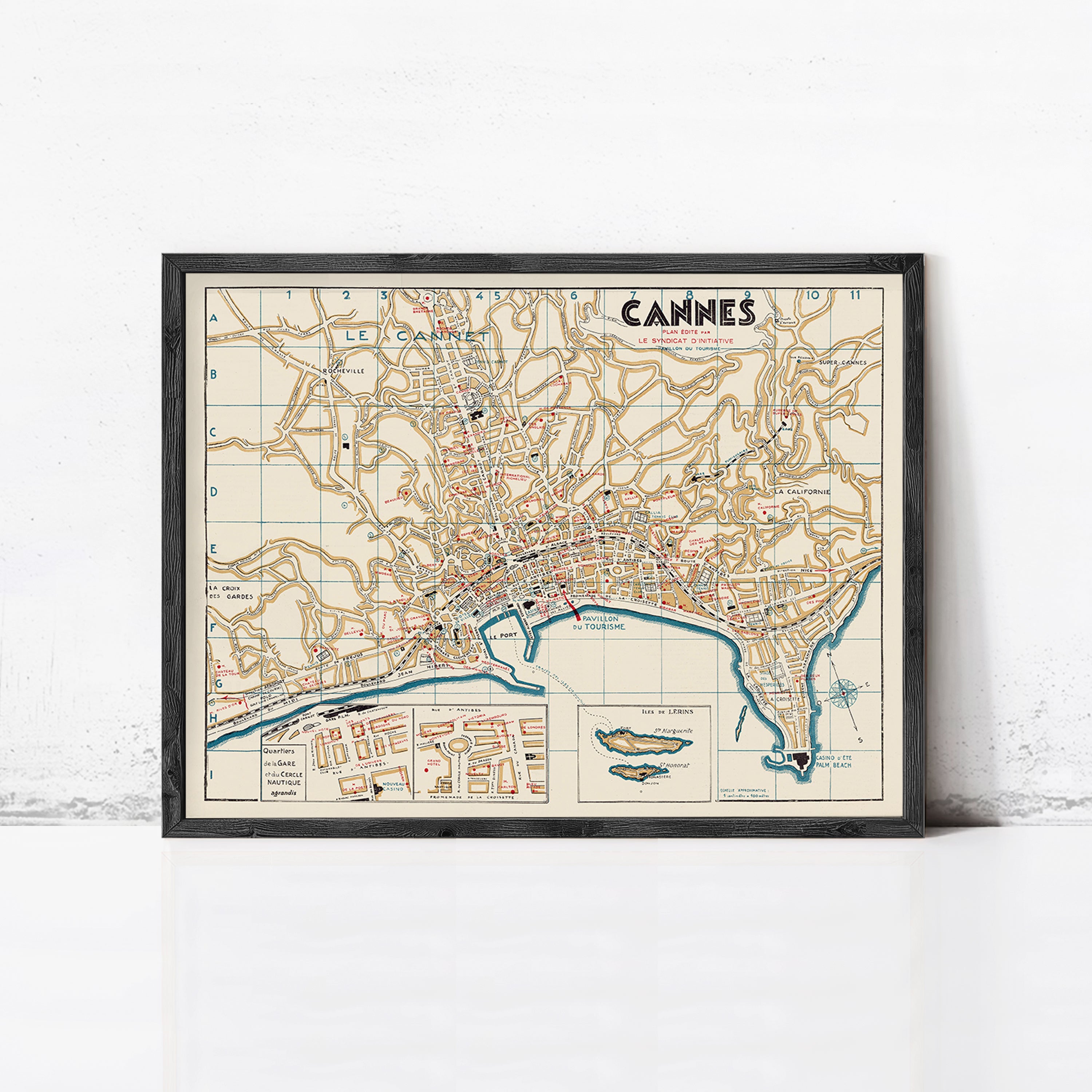 The image is a framed vintage map of the city of Cannes, France, depicting the city's streets, landmarks, and surrounding areas.