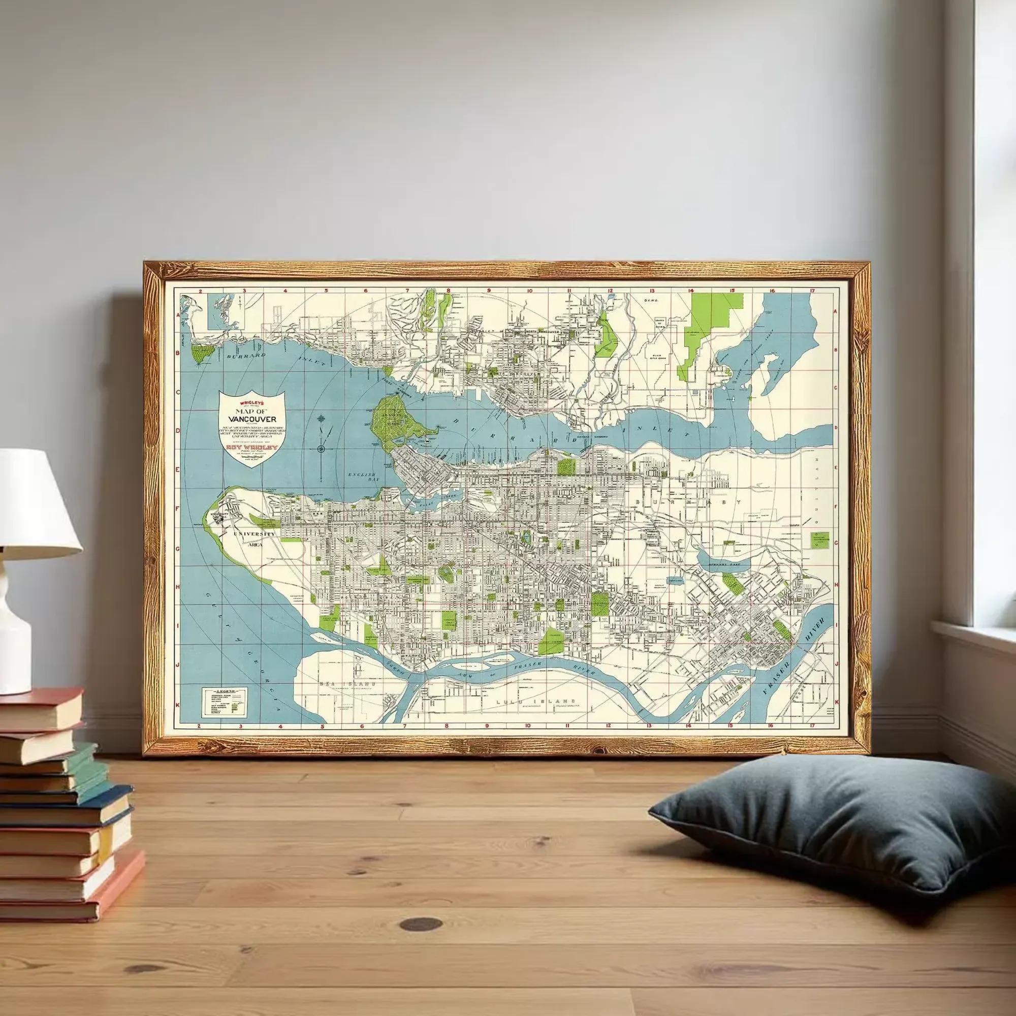 a large framed map of Vancouver, Canada, with a wooden floor and a stack of books nearby.