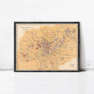 The image is a framed vintage map of a city, likely from the 19th century, with a grid-like layout and various landmarks and streets labeled.