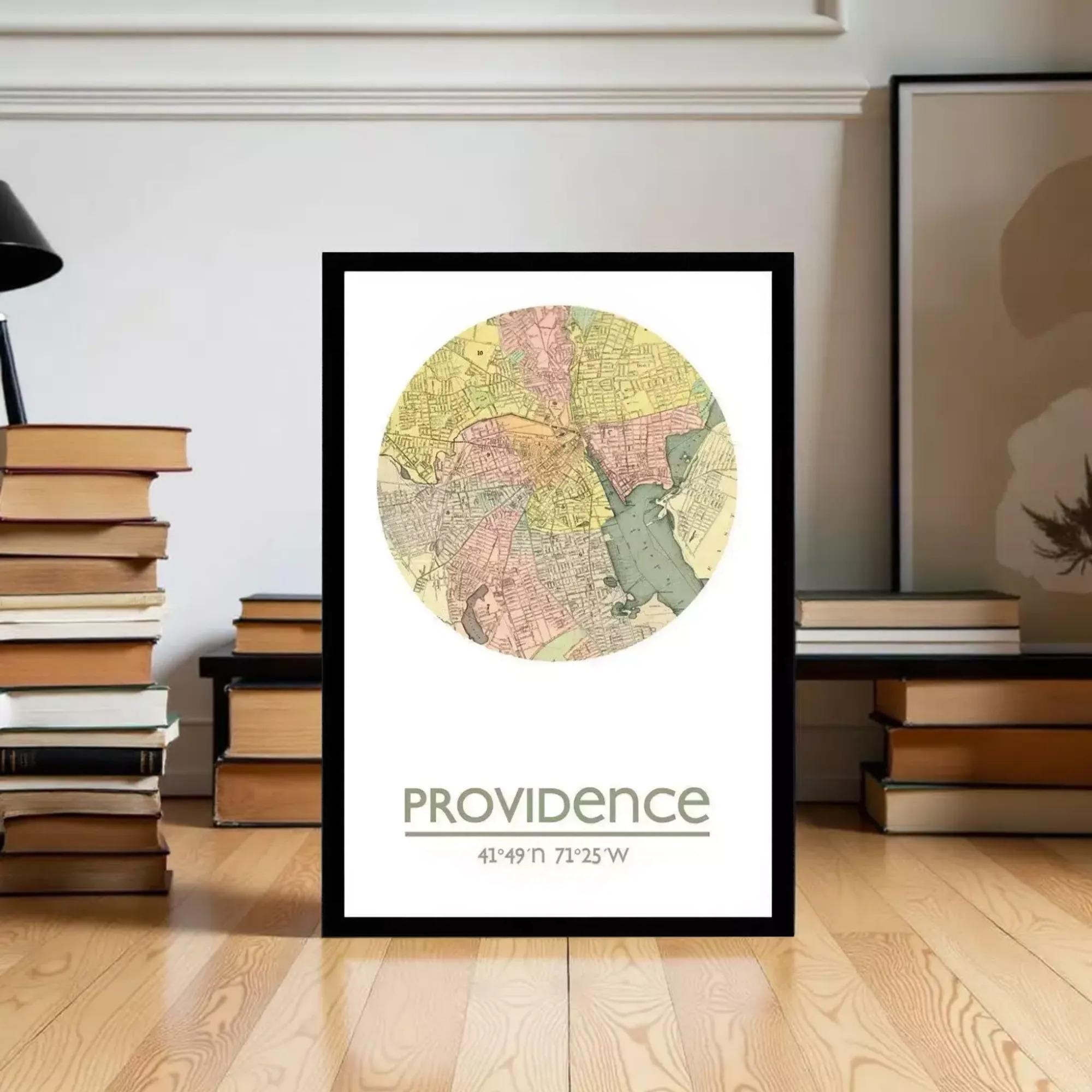 A framed map of Providence, Rhode Island, with the city's name and location printed on it, placed on a wooden floor in front of a stack of books.