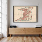 A framed map of Trinidad and Tobago is displayed on the wall above a wooden cabinet or entertainment center.