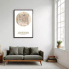 a living room with a gray sofa, a framed map of Savannah hanging on the wall, and a window with a plant on the sill.